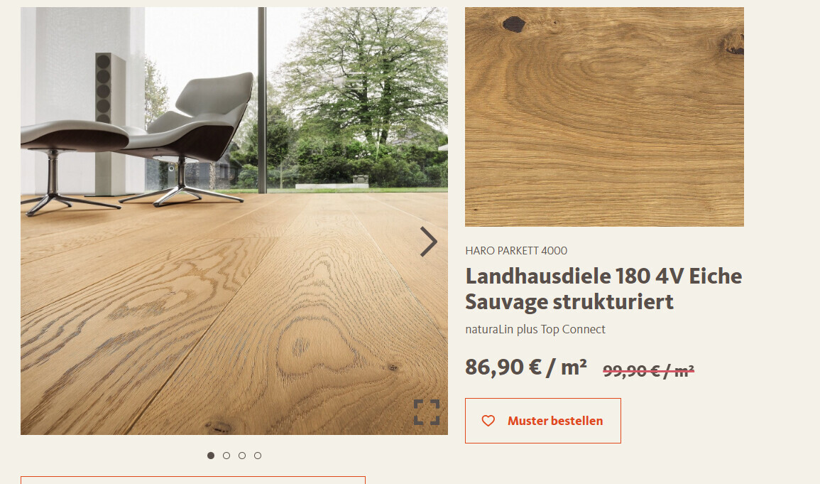 Wohnzimmer mit hellem Holzboden, Lounge-Stuhl und großen Fenstern mit Blick aufs Grün.