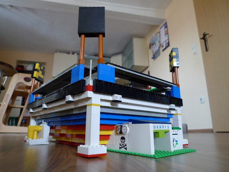 Farbiges LEGO-Hausmodell mit mehreren Ebenen auf Wohnzimmerboden.