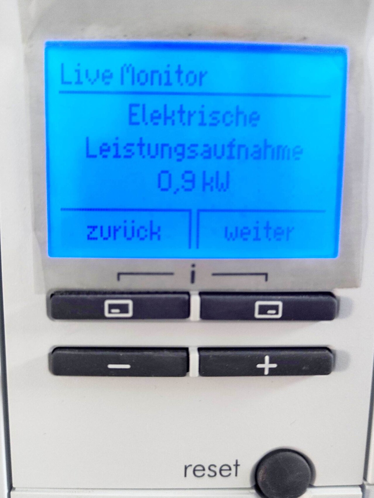 Live-Monitor eines Messgeräts zeigt elektrische Leistungsaufnahme 0,9 kW sowie Zurück/Weiter.