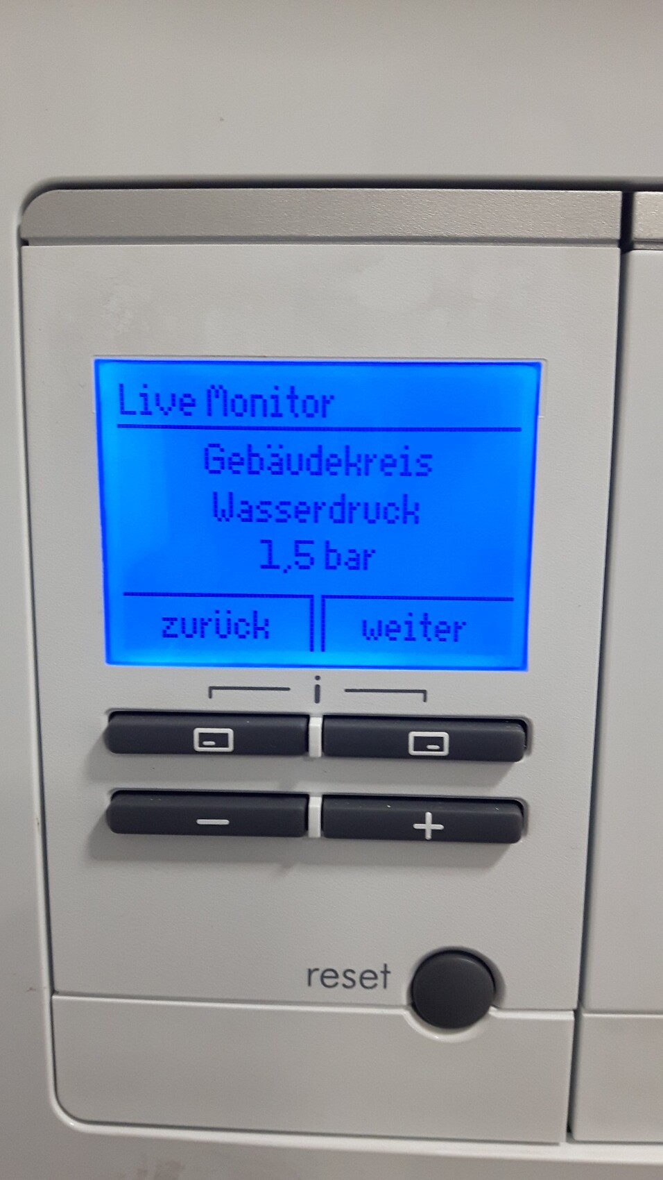 Blaues LCD-Bedienfeld zeigt Live Monitor: Gebäudekreis, Wasserdruck 1,5 bar; Zurück/Weiter.