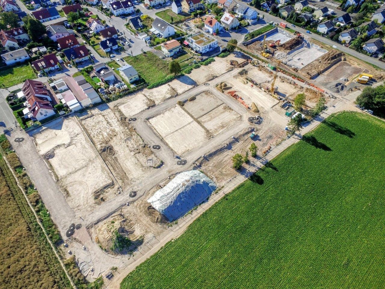 Luftaufnahme einer Baustelle mit Fundamentgruben in einer Wohngegend