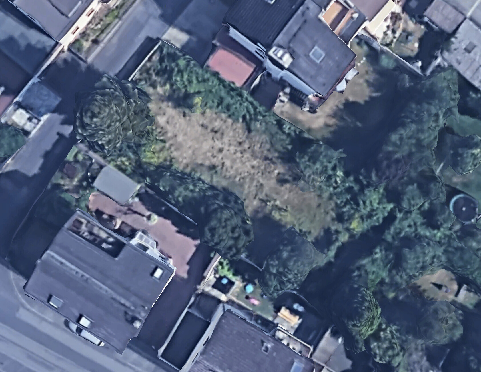 Luftaufnahme eines Wohnviertels mit Häusern, Straßen und dichtem Baumbestand.