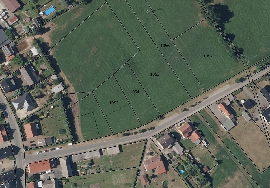 Luftaufnahme eines Wohngebiets mit Parzellen 1053–1057 und angrenzender Straße.