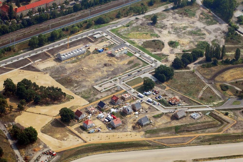 Luftbild einer Baustelle und Siedlung: Bauhäuser, Fahrzeuge, Straßen und Grünflächen