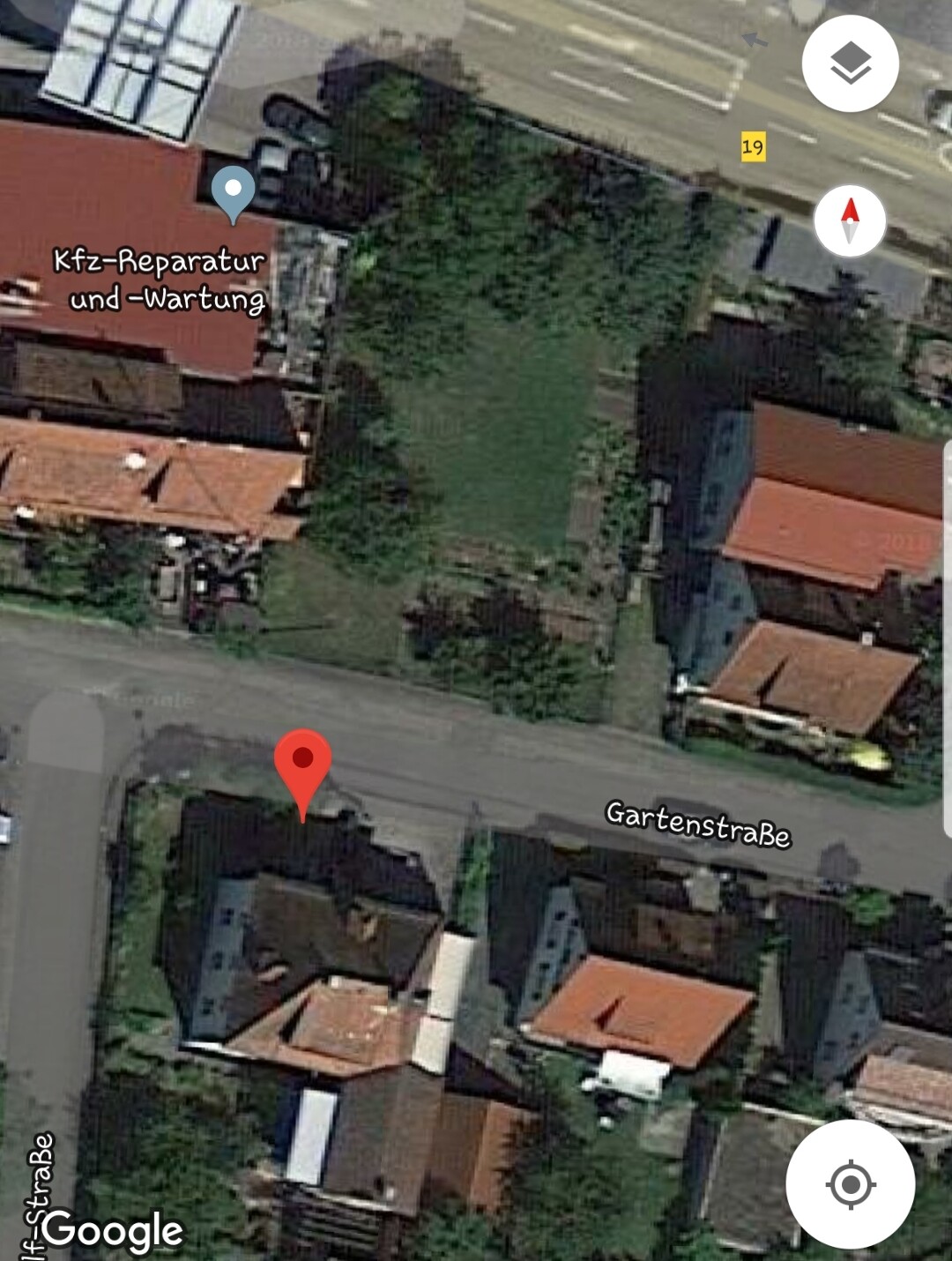 Luftaufnahme von Wohnhäusern mit Gaerten und Strasse