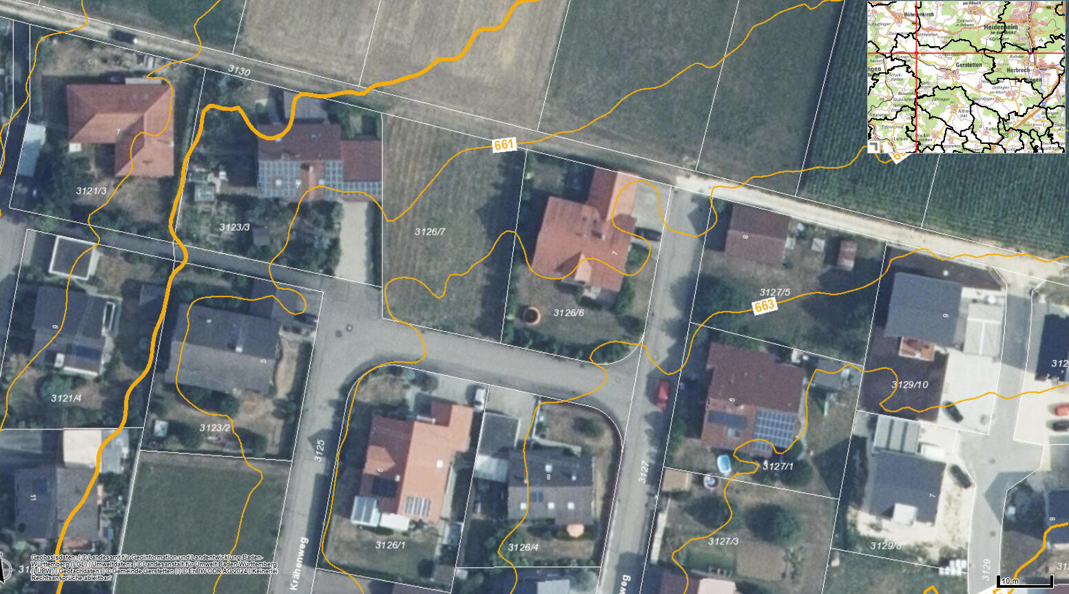 Luftaufnahme einer Wohnsiedlung mit Parzellen, Straßen und orange Grenzlinien.