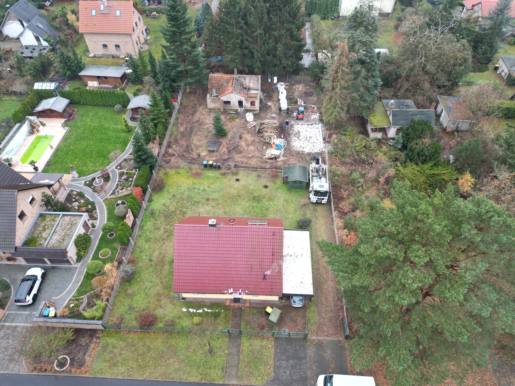 Luftbild eines Wohnviertels mit Garten, Bauarbeiten im Hinterhof und Bauequipment