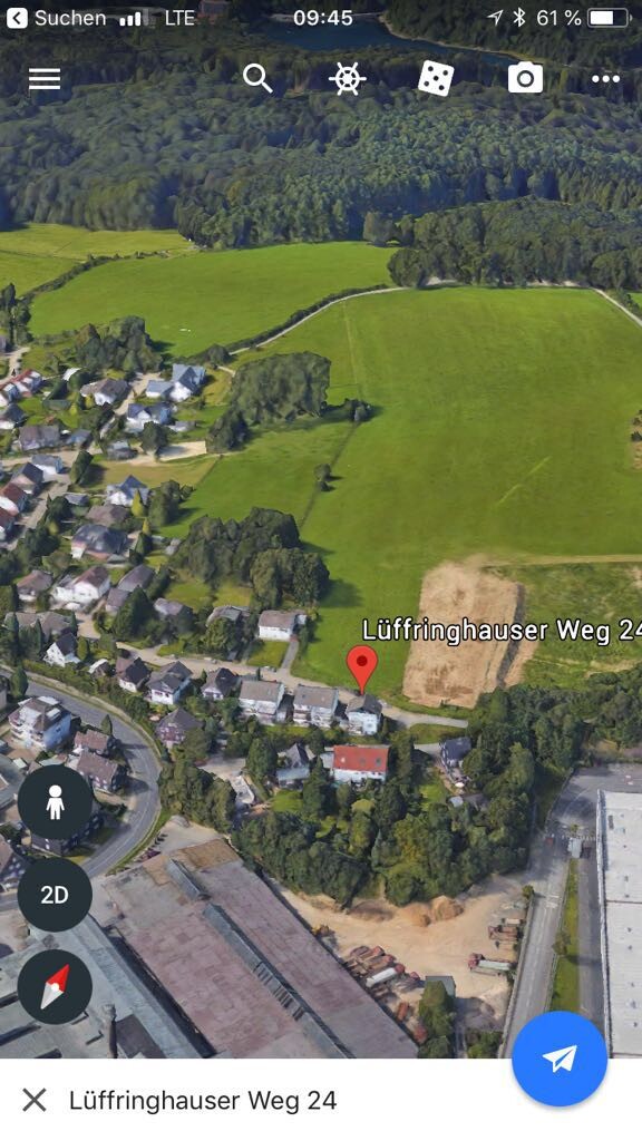 Luftbild einer ländlichen Siedlung mit Feldern, Häusern und Wald