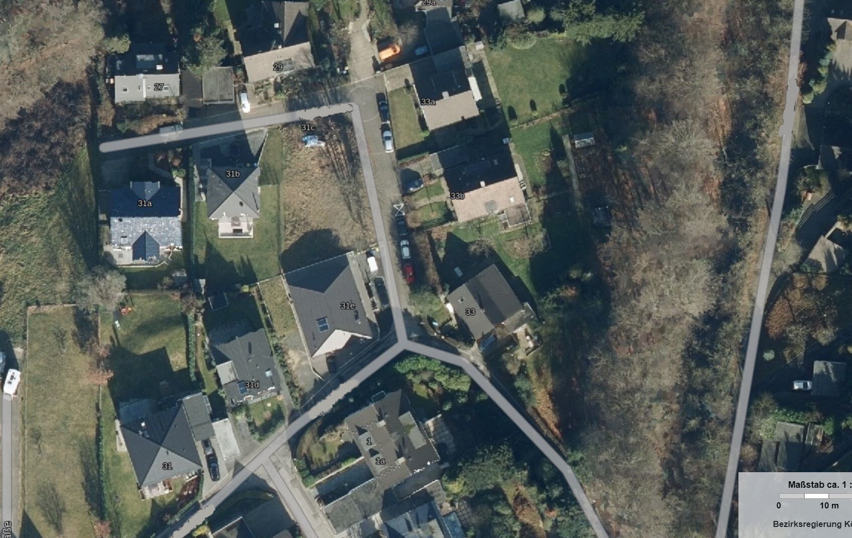 Luftbild eines Wohngebiets mit Häusern, Gärten und Straßen aus der Vogelperspektive