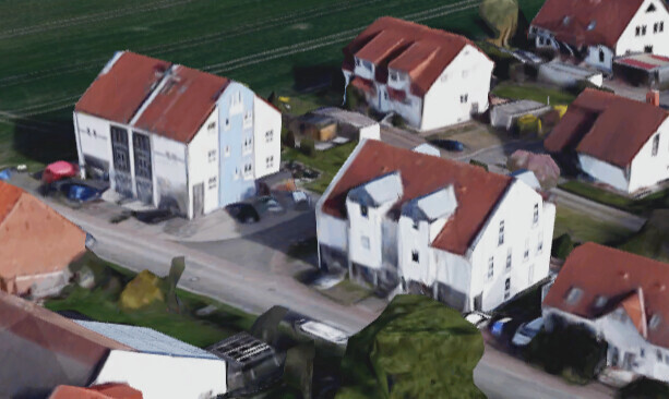 Luftbild eines Wohnviertels mit weißen Häusern und roten Dächern.
