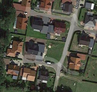 Luftaufnahme eines Wohngebiets mit Häusern, Straßen und Gärten