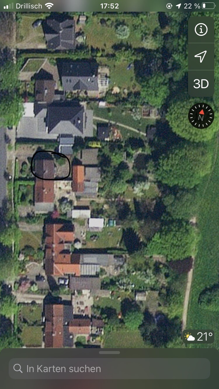Luftaufnahme eines Wohnviertels mit Häusern, Gärten und Bäumen; Kreis markiert Gebäudeteil.