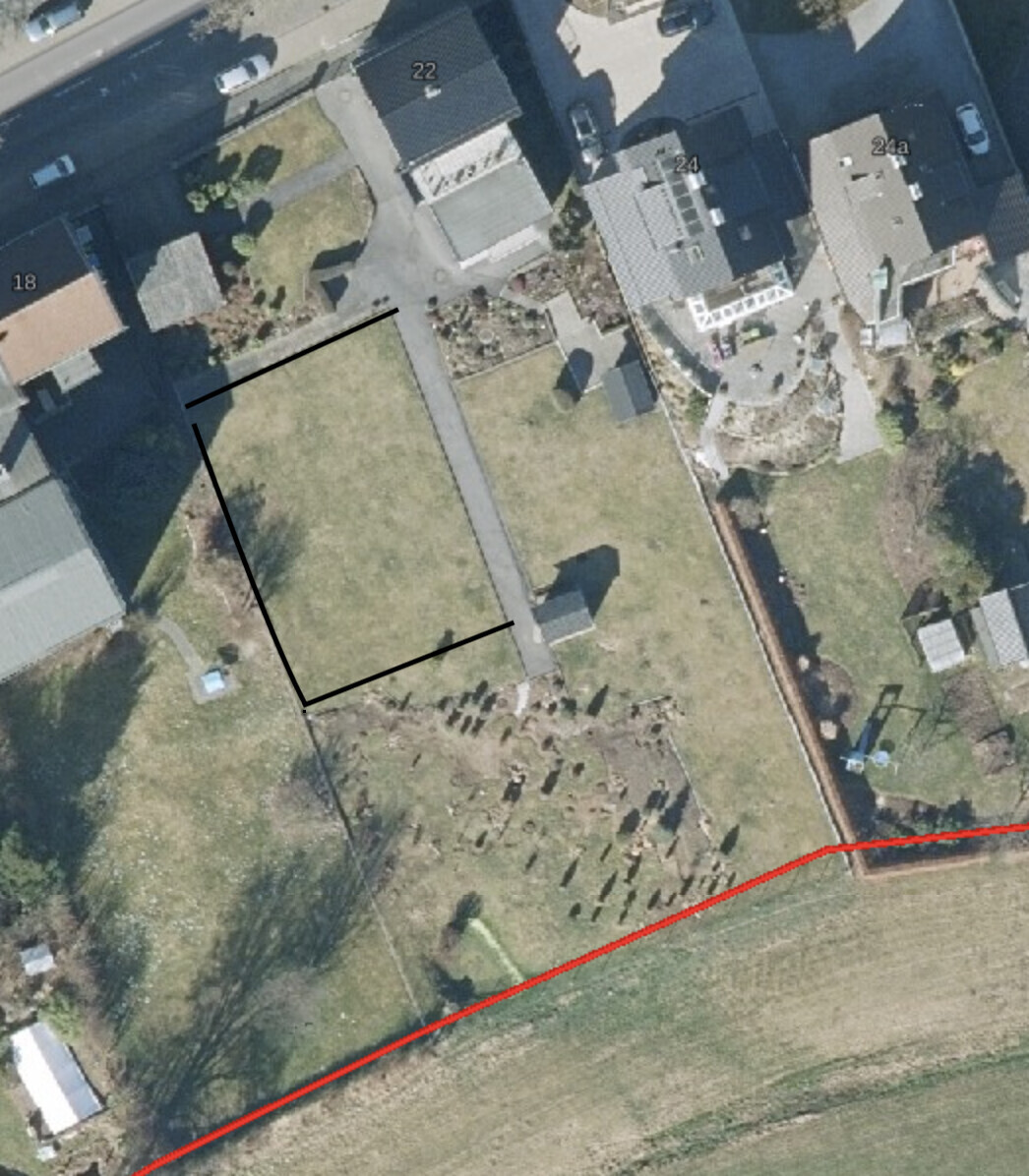 Luftbild eines Wohnviertels mit angrenzendem Friedhof, Gräberreihen und roter Randlinie.