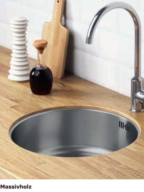 Küchenarbeitsplatte aus Massivholz mit runder Edelstahlspüle, Wasserhahn, Schneidebrett und Ölflasche.