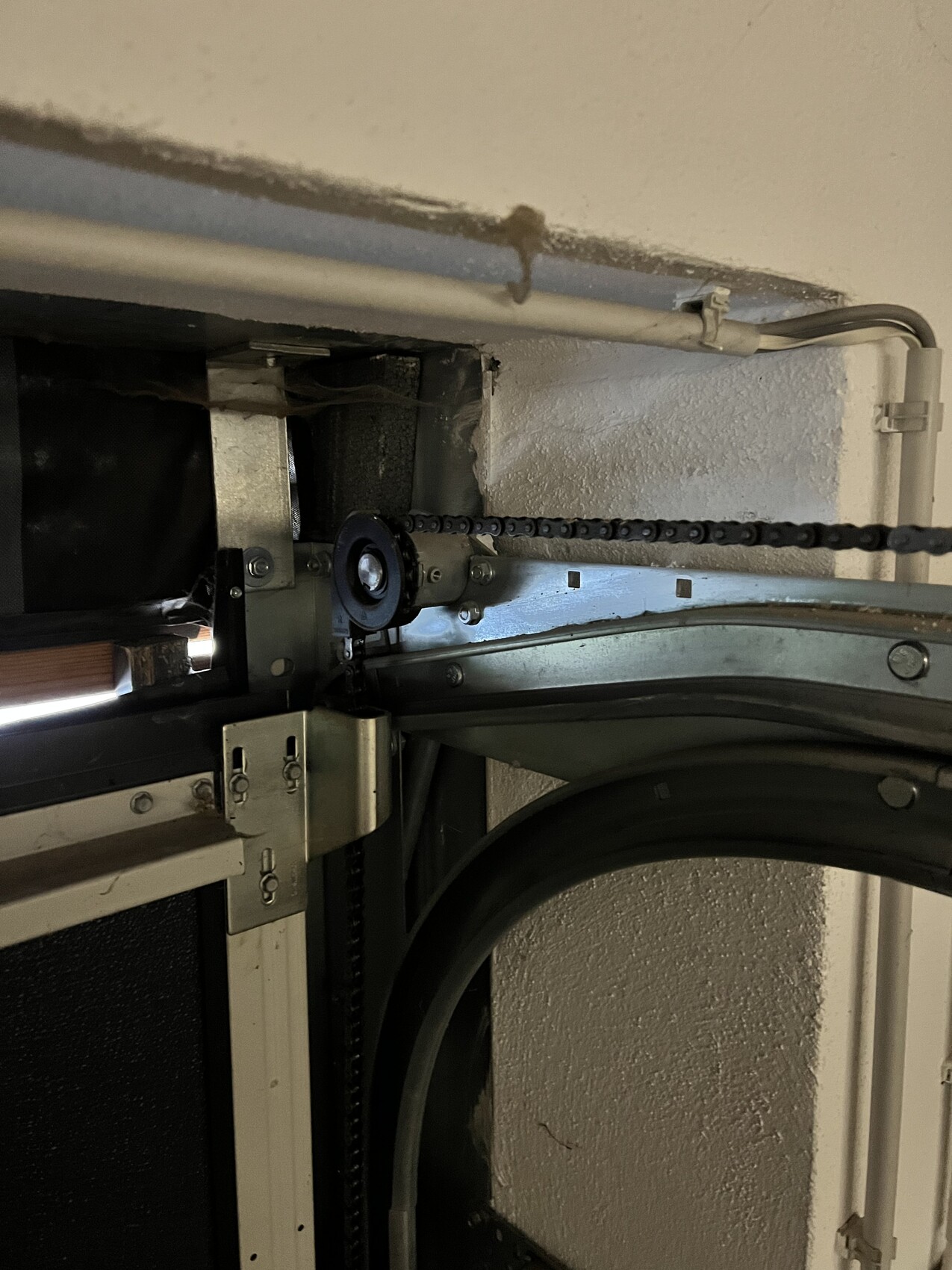 Innenansicht einer industriellen Maschine: Kette läuft über Zahnrad, Führungsschiene.