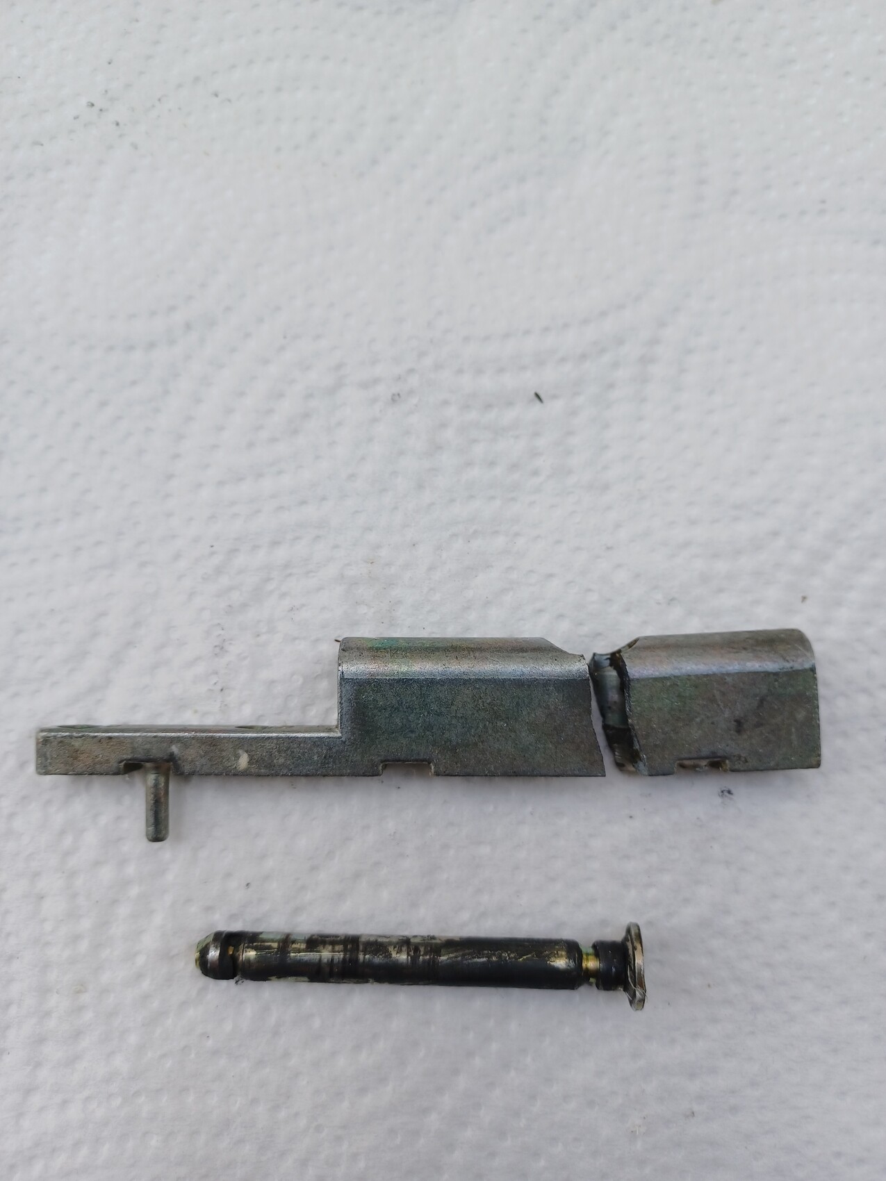 Zerlegtes Metallschloss-Beschlag-Set mit Stift auf hellem Hintergrund