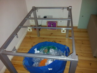 Metallbettgestellrahmen im Schlafzimmer auf Holzboden ohne Matratze.