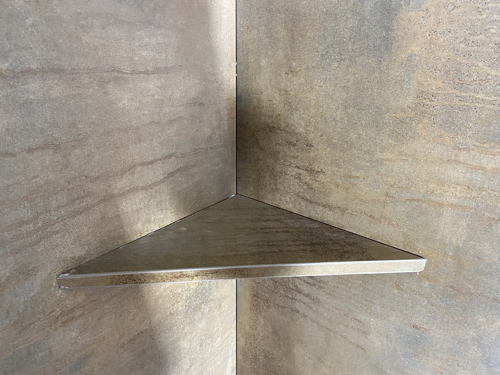 Metall-Eckablage in braun marmorierter Badezimmerwand in der Ecke