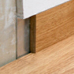 Nahaufnahme einer Metall-Tuer-Schwelle zwischen Holzboden, Fokus auf Bodenkante