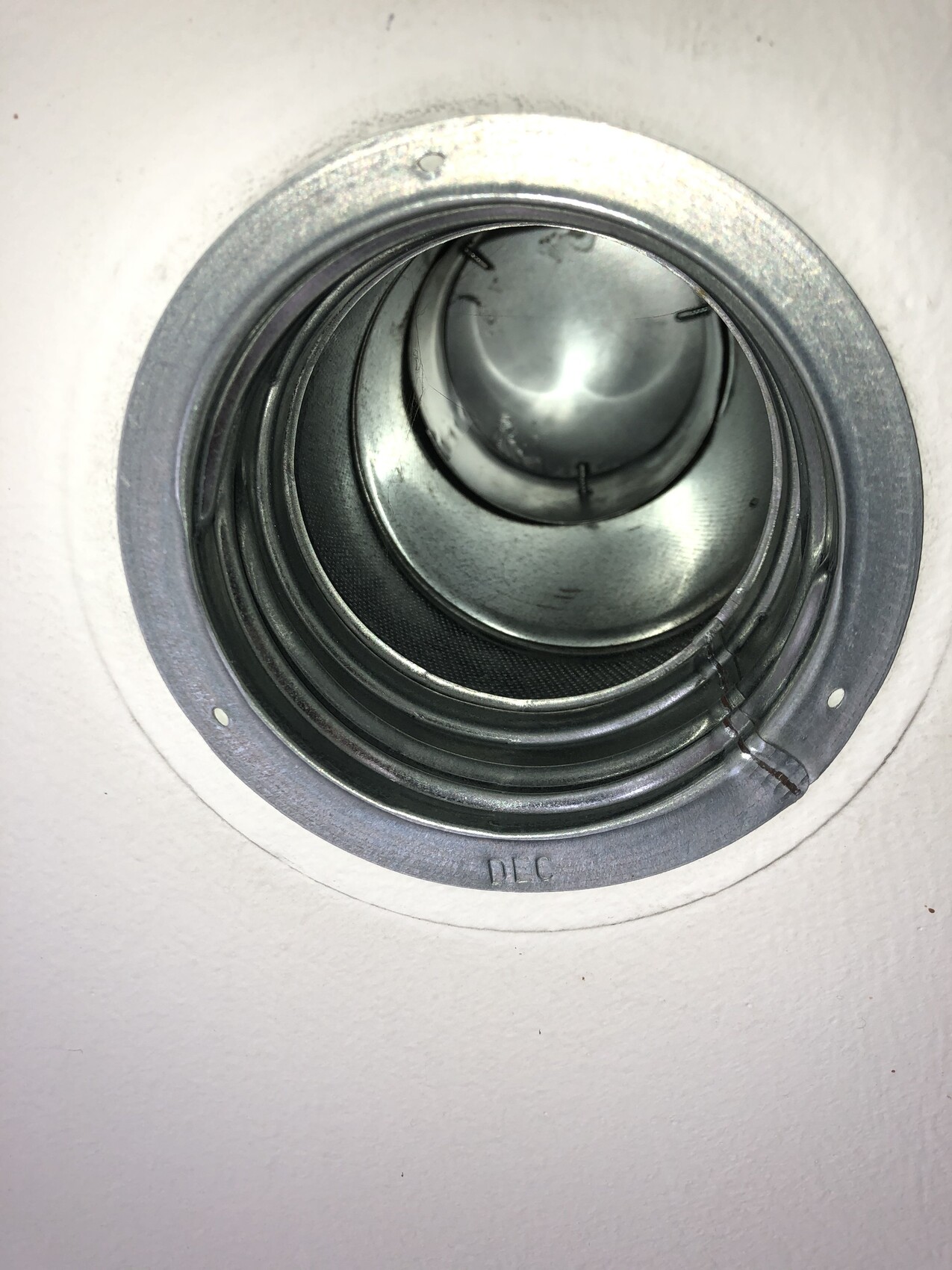 Rundes Metall-Einbau-Deckenlichtgehäuse in der Deckenöffnung mit inneren Ringen.