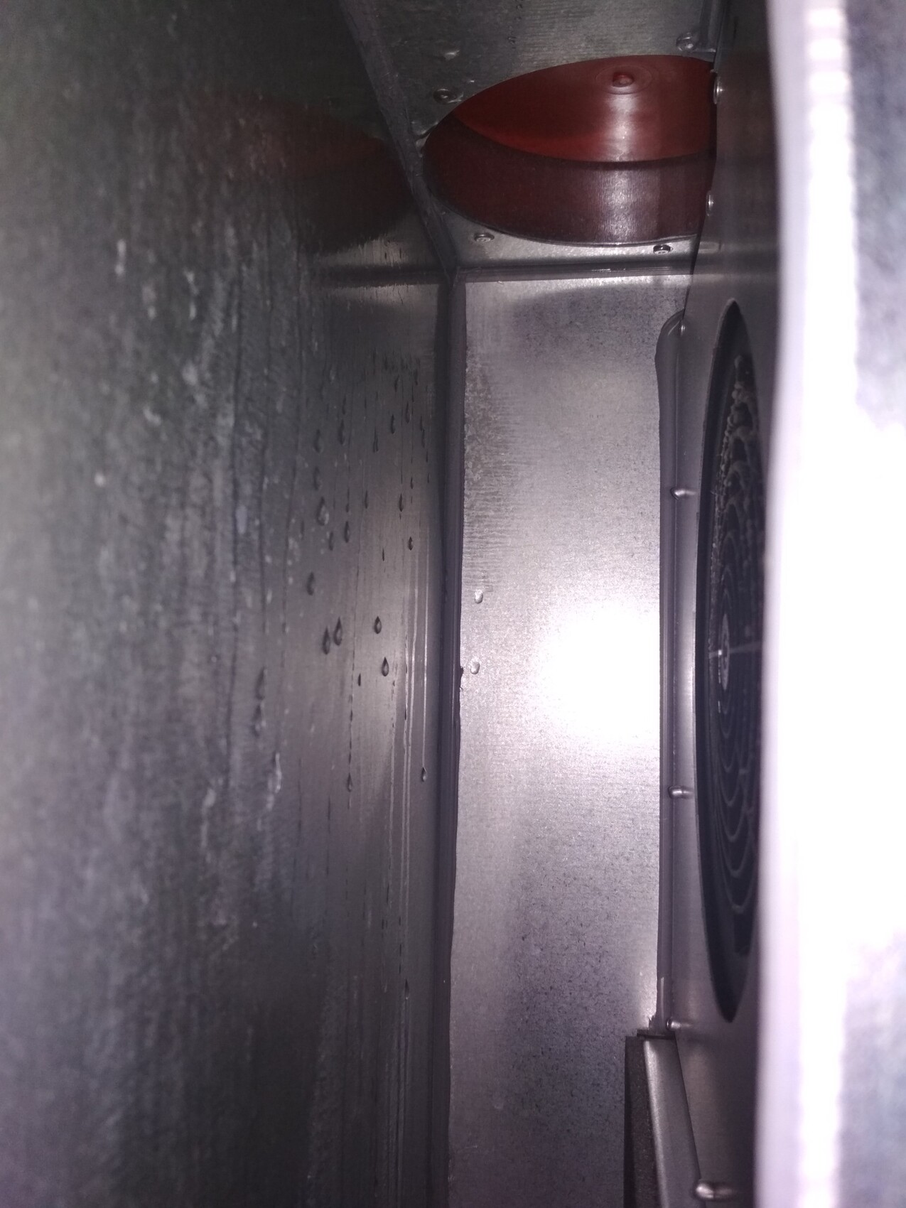 Innenansicht einer metallischen Lüftungsanlage im Schacht mit Ventilator