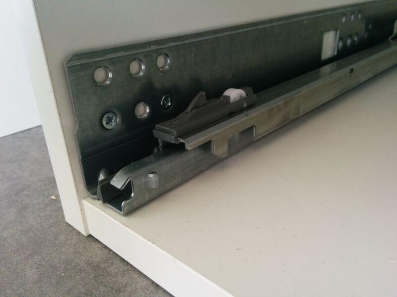 Metallische Schubladenschienen im offenen Küchenschrank sichtbar