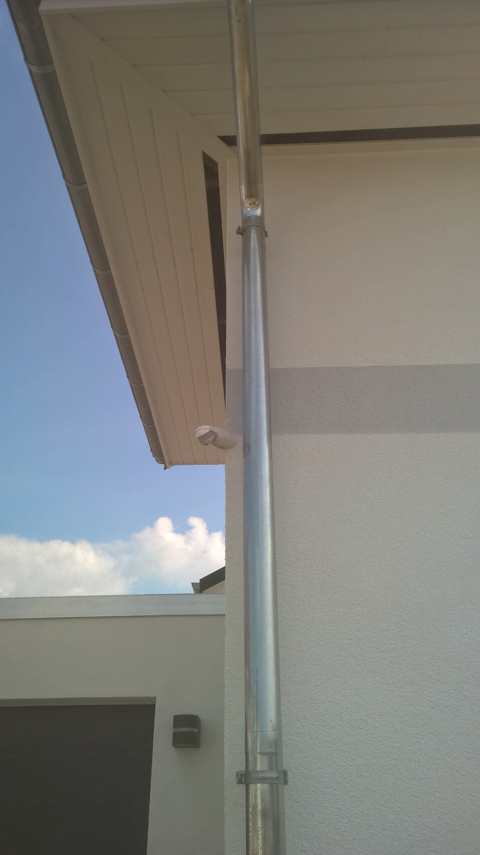 Metallisches Fallrohr an der Außenfassade eines Hauses, Teil der Dachentwässerung