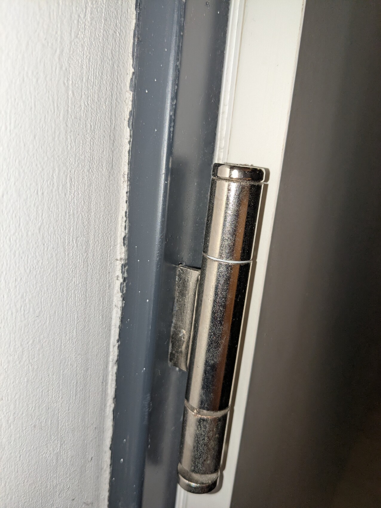 Metallisches Türscharnier am Türrahmen einer Innenzimmertür