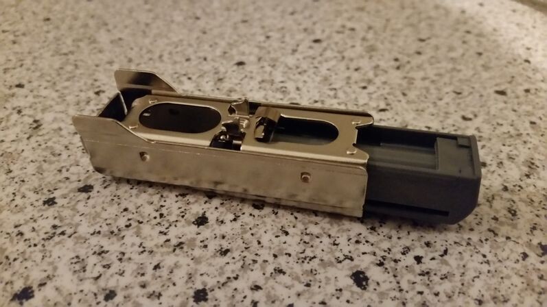 Metallischer Adapter/Steckteil mit schwarzem Kunststoffstecker, liegt auf Granitfläche.