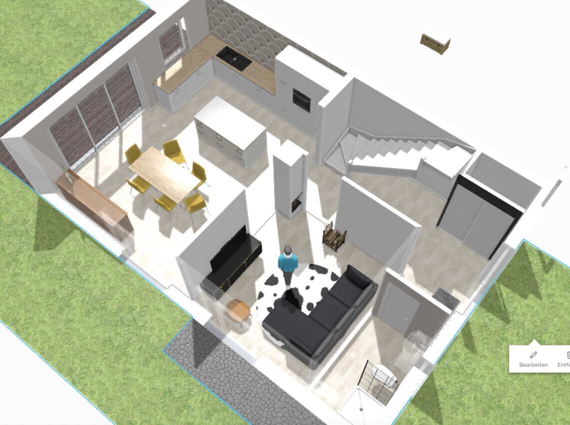 Offene Küche mit Insel und Esstisch, Wohnzimmer mit Sofa, Treppe und Person im Raum.