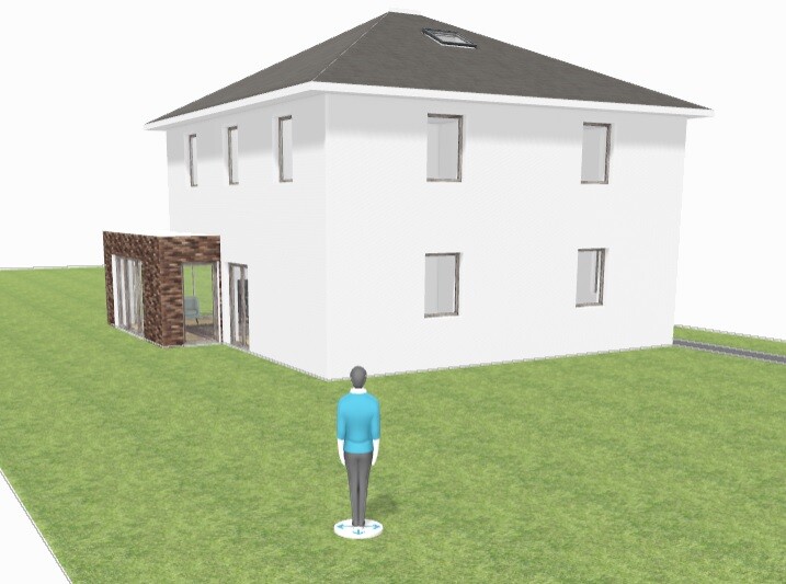 Eine Person steht auf grünem Rasen vor einem weißen, zweistöckigen Haus mit grauem Dach.