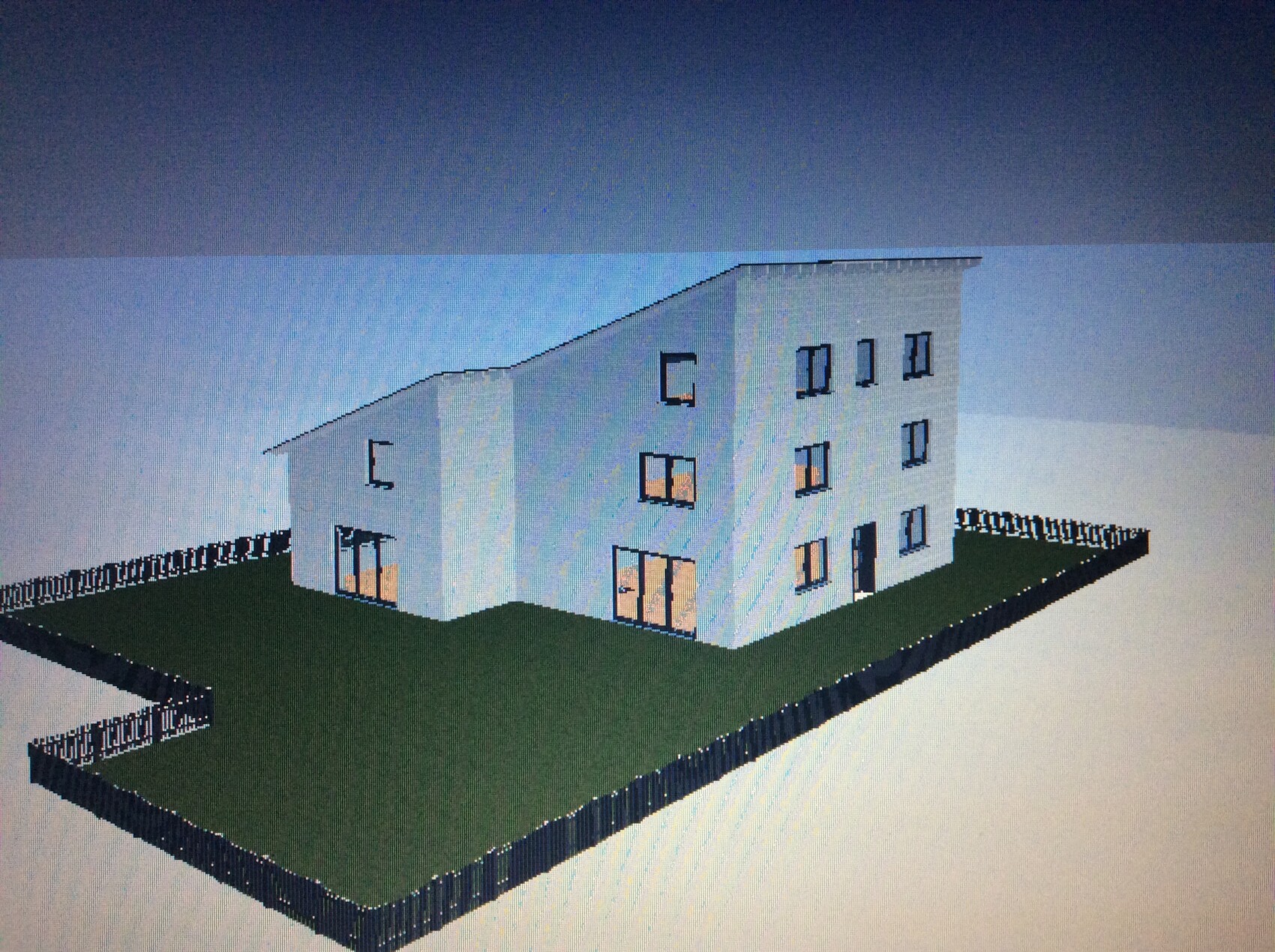 Modernes zweistöckiges Haus aus zwei verbundenen Bauteilen, Gartenfläche und umlaufendem Zaun.