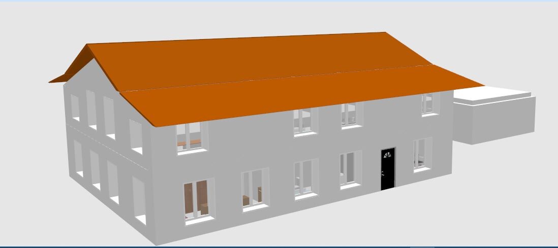 Mehrstöckiges graues Haus mit rotem Satteldach, vielen Fenstern, schwarzer Eingangstür und rechteckigem Anbau.
