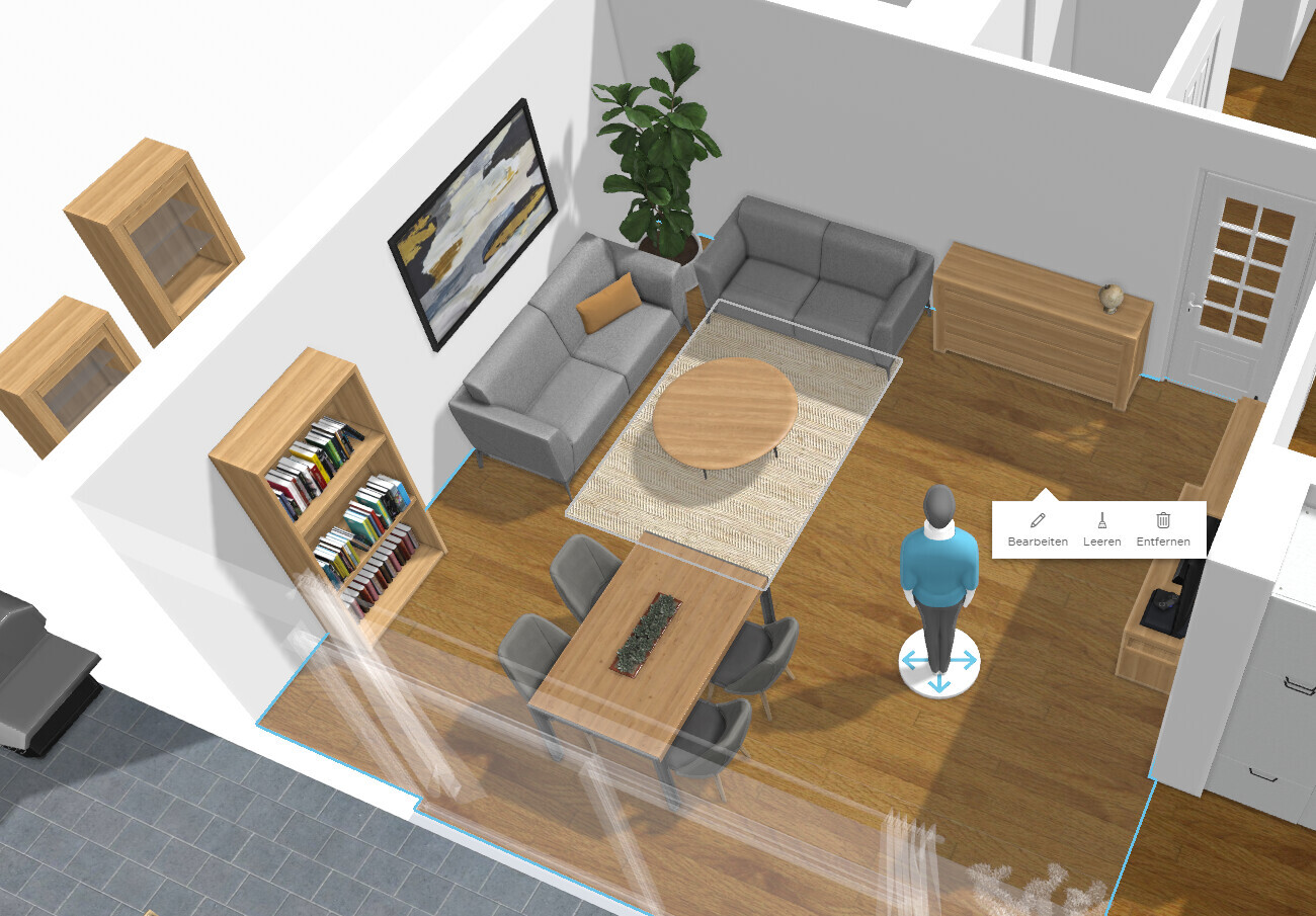 Wohnzimmer mit grauen Sofas, runder Holztisch, Esstisch mit Stühlen, Bücherregal, Pflanze