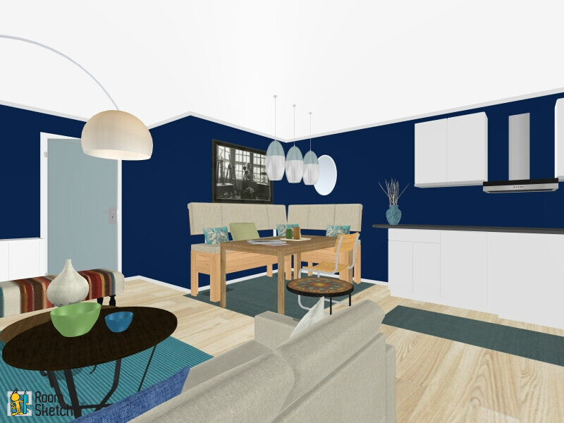 Offenes Wohnzimmer mit Esstisch, heller Sofa, blaue Wände, Küche mit weißen Schränken