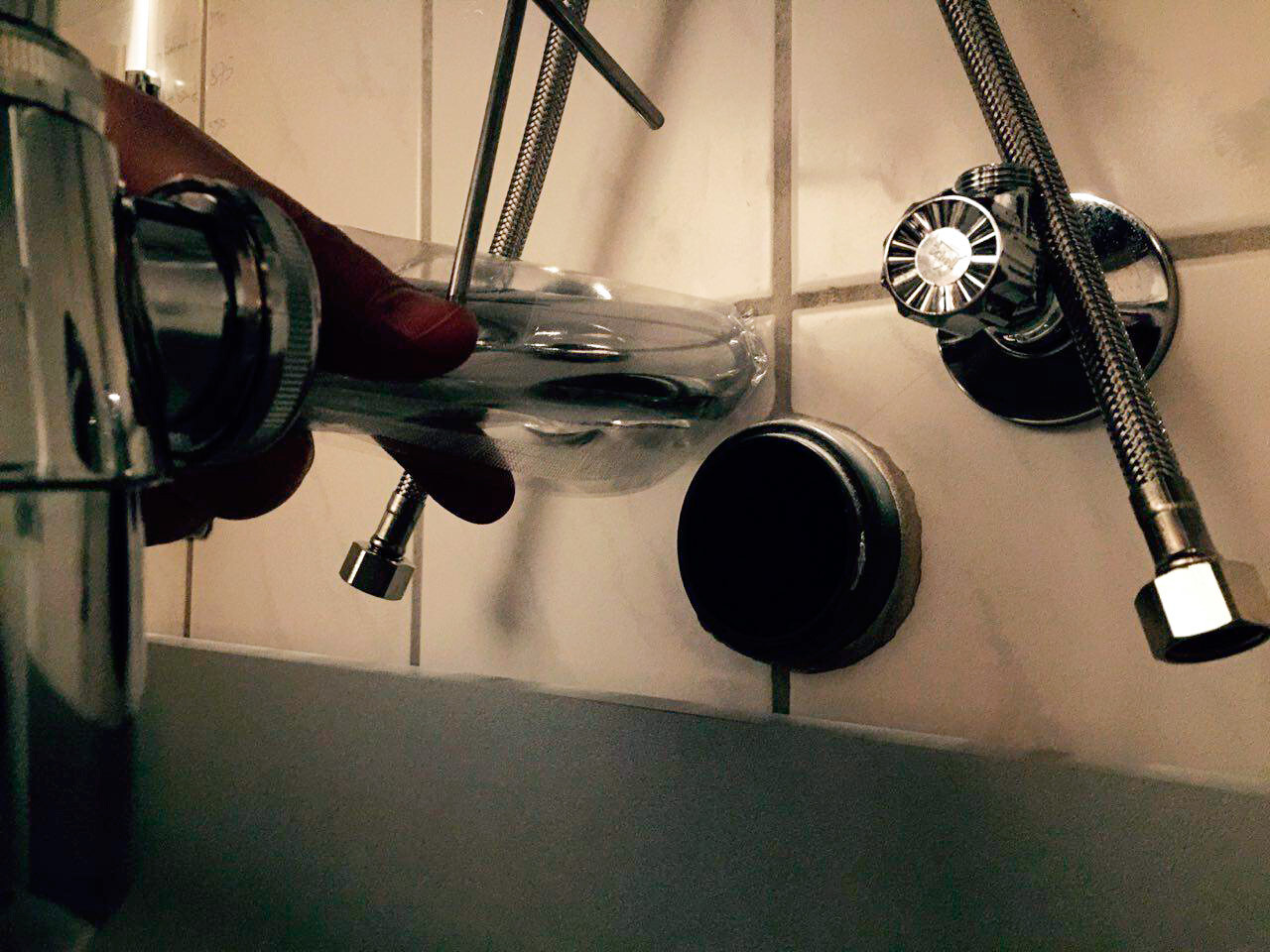 Nahaufnahme einer modernen Chromarmatur im Bad mit flexiblem Brauseschlauch über dem Spülbecken
