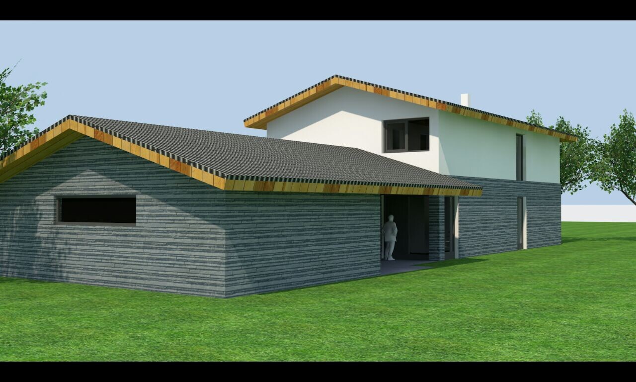 Außenansicht eines modernen Hauses mit grauen Steinwänden, Dach und gruenem Rasen.