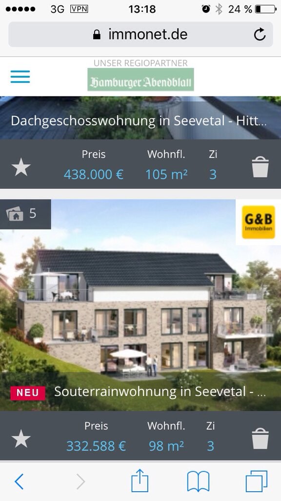 Modernes Mehrfamilienhaus mit Steinfassade, Balkonen und Garten.