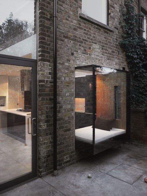 Moderne Backsteinfassade mit Glaszimmer und Terrasse im Innenhof