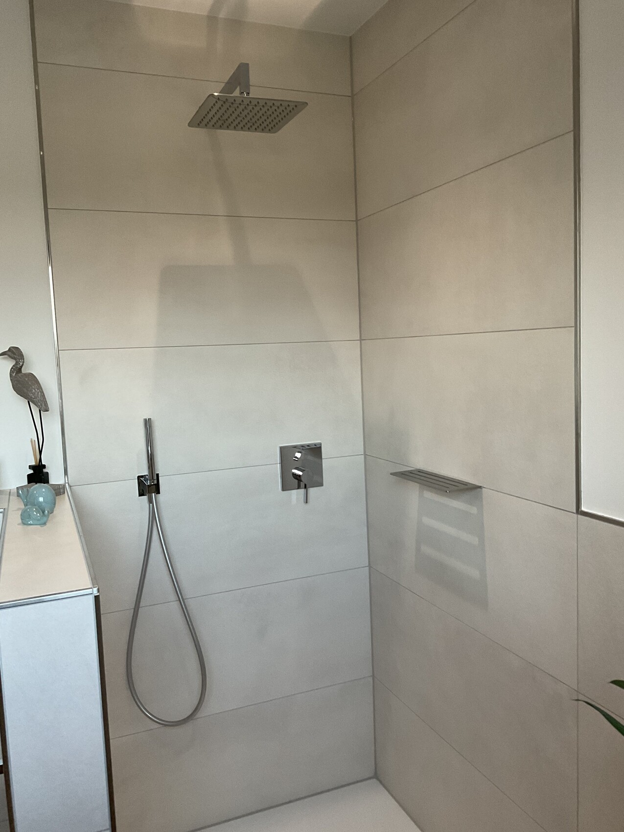 Moderne begehbare Dusche: großer quadratischer Regenkopfduschkopf, Handbrause und Armaturen.