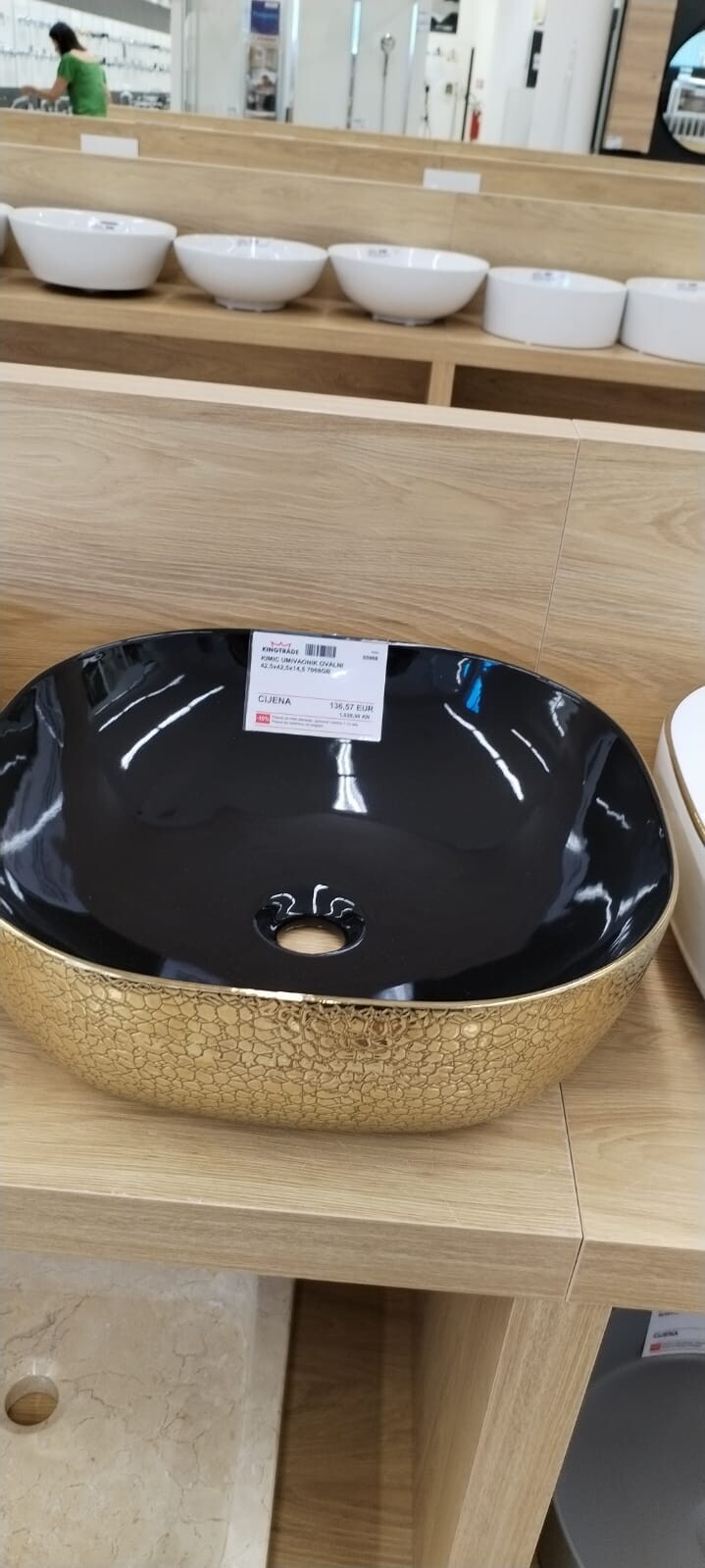 Großes ovales Waschbecken mit schwarzer Innenfläche und goldener Crackle-Optik; Preisschild.