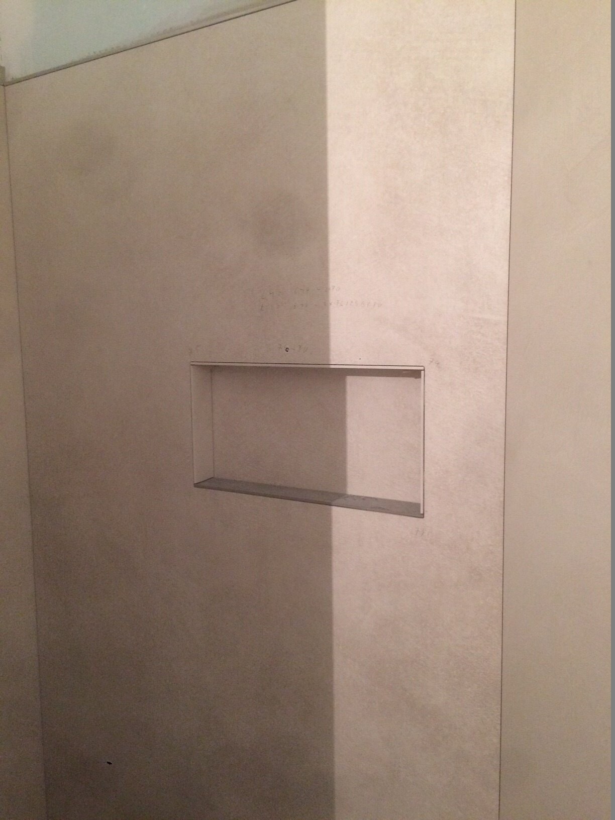 Offene, rechteckige Wandnische in einer glatten Wand mit sichtbarer Einfassung.