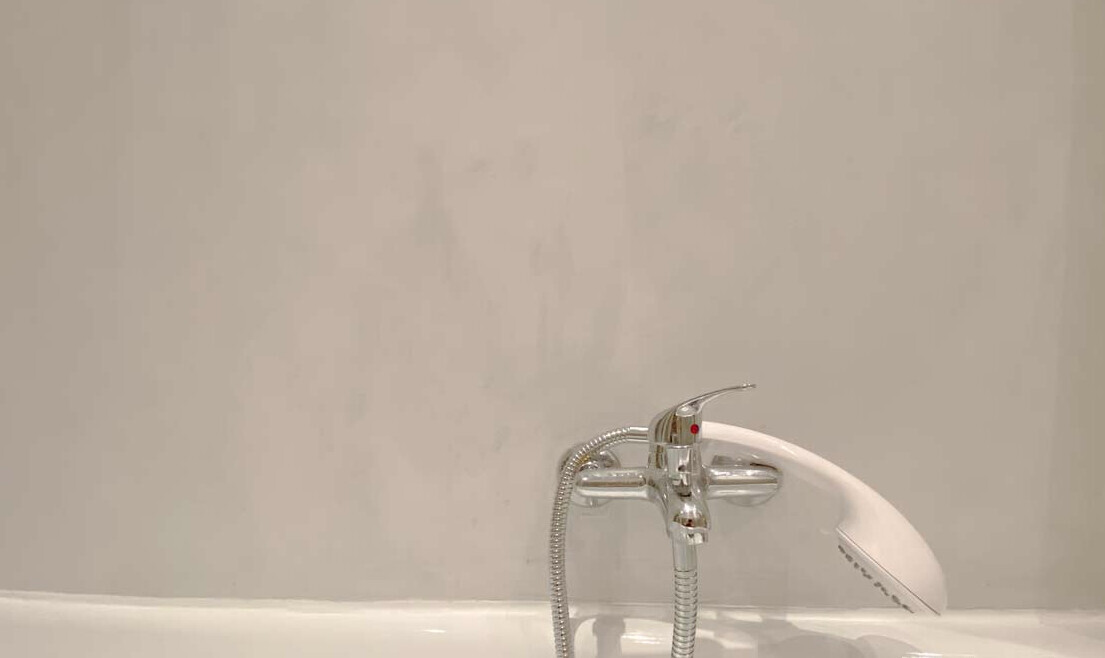 Badezimmer-Wannenarmatur mit Duschkopf und flexiblem Schlauch über der Badewanne