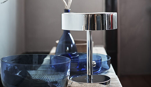 Moderne Chrom-Badarmatur mit blauem Glasgeschirr auf dem Waschtisch