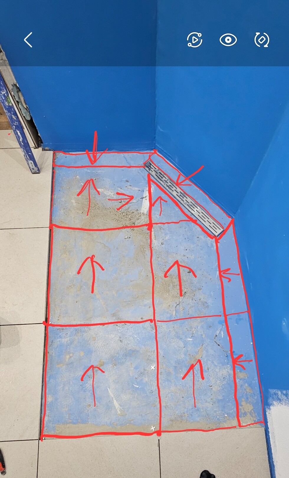 Bauzone: Boden mit rotem Fliesen-Raster, Pfeile zeigen Verlegung; Metalldrainage am Rand.