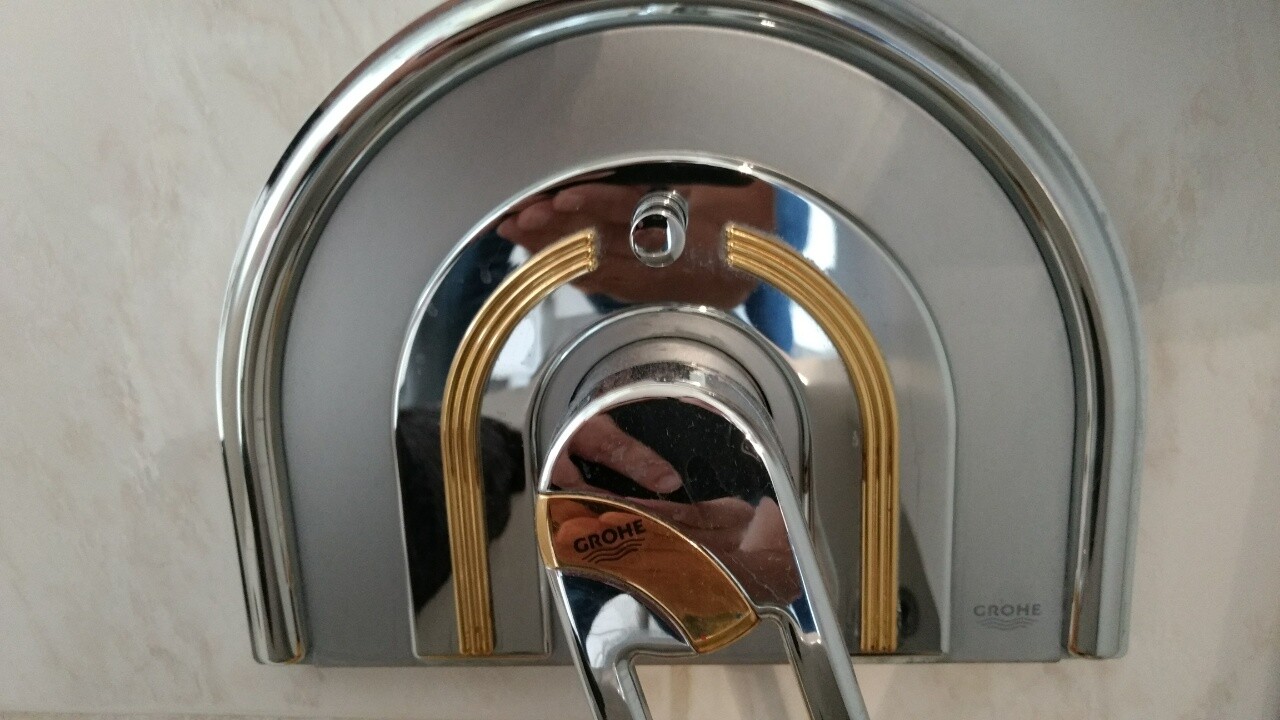 Moderne chromierte Dusche-Mischbatterie mit zwei goldenen Bögen und Grohe-Logo