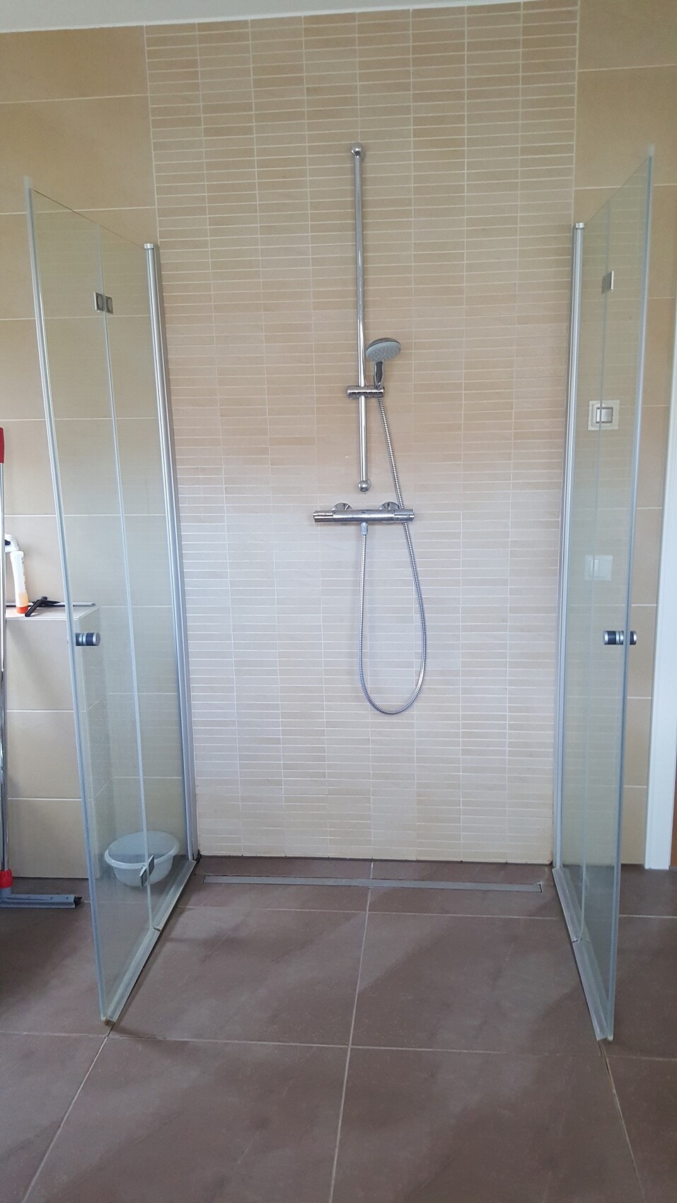 Moderne Duschkabine mit Glaswänden, Wandstange und Handbrause.