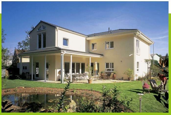Modernes zweigeschossiges gelbes Haus mit Terrasse, Garten und Teich im Vordergrund.
