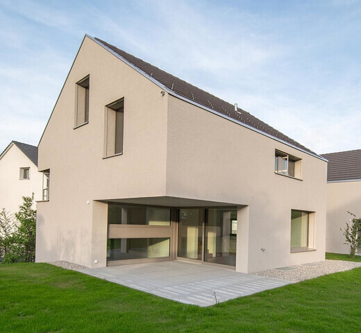 Modernes zweistöckiges Einfamilienhaus mit Glasfront und Garten.