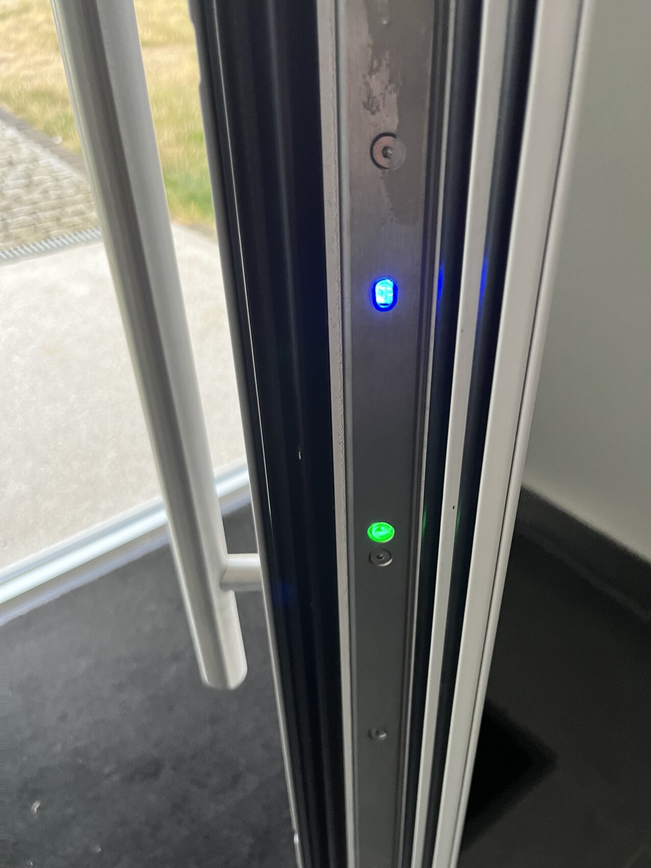 Türrahmen eines Fahrzeugs mit blauer und grüner LED-Anzeige neben dem Türgriff.